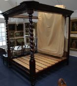 A Victorian mahogany four poster bed, with barley twist end posts, step moulded pediment and