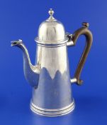 A George V early 18th century style silver coffee pot, with turned finial and panelled spout,