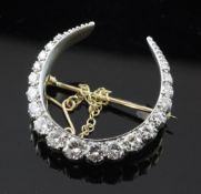 A gold and graduated diamond set crescent brooch, with a total estimated diamond weight of 1.55ct,