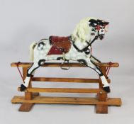 A 20th century dapple grey rocking horse, on pine base, approx. 48in.