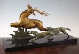 E. Guy. An Art Deco parcel gilt bronze group of two hounds chasing a stag, signed, on black marble