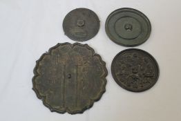 Four Chinese bronze hand mirrors, Tang Dynasty or later, the first with eight petal lobed order