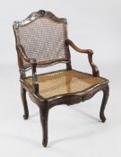 An 18th century French stained and carved beech fauteuil, with cane back and seat, with floral