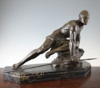 An Art Deco bronzed spelter figure of a huntsman, kneeling upon a rock and clasping a spear, on