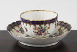 A Worcester polychrome fluted tea cup and saucer, c.1775, with a gilded scalloped rim, the cup