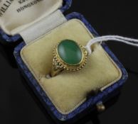A 1940`s Chinese gold and cabochon jadeite ring, with beaded border, in Williams & Co, Kowloon,