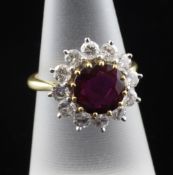 An 18ct gold, ruby and diamond cluster ring, the central ruby weighing approximately 1.50ct, size