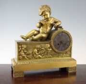 An Empire ormolu mantel clock, surmounted with a putto reading a scroll reclining against the drum