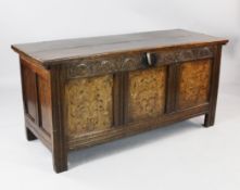 A large 18th century oak coffer, the triple panel front with floral marquetry inlay between moulded