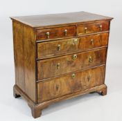 An 18th century featherbanded walnut chest, of two short and three long drawers, with pendant drop
