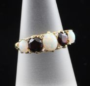 An 18ct gold, garnet and white opal half hoop ring, the carved setting set with two garnets and
