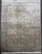 A Cinar silk rug, with geometric field of scrolling foliage, on a pale green ground, with multi row