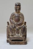 A Chinese wood seated figure of an official, 17th / 18th century, with traces of polychrome