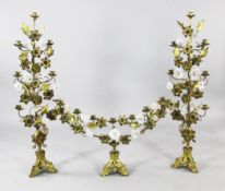 A garniture of three 19th century French gilt brass candelabra, applied with white porcelain