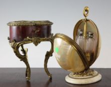 A large 19th century gilt metal and mother of pearl scent bottle stand, of egg shape, opening to