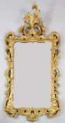 A George II carved giltwood wall mirror, with acanthus scroll crest and rocaille and C scroll