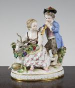 A Meissen group of a boy and girl, late 19th century, she seated on a recumbent goat and holding a