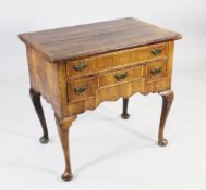 An early 18th century walnut lowboy, fitted an arrangement of four drawers above a shaped apron, on