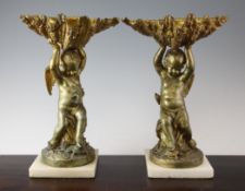 A pair of late 19th century ormolu figures, modelled as winged cherubs, holding shells above, on