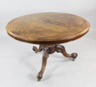 A Victorian walnut circular breakfast table, with central gadrooned vase shaped column and three