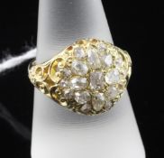 A Victorian 18ct gold and diamond cluster ring, with ornate pierced shoulders and set with nineteen