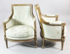 A pair of Louis XVI carved giltwood bergeres, upholstered in a pale green damask fabric, with twist