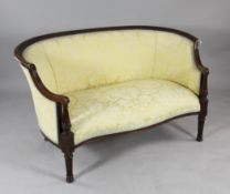 A 19th century French carved mahogany canapé, the serpentine seat upholstered in a yellow patterned