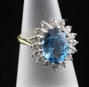 A 1970`s 18ct gold, blue topaz and diamond cluster ring, of oval form, size M.