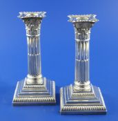 A pair of George V silver corinthian column candlesticks, on stepped square bases, P.G. Dodd & Son,