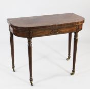 A Regency mahogany and ebony line inlaid D end folding card table, on tapering legs with castor