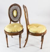 A pair of neo-classical revival satinwood salon chairs, with oval cane backs centred with an oval