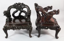 A pair of Japanese carved armchairs, Meiji period, the back and arms modelled as two entwined