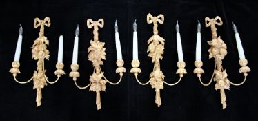 A set of four carved giltwood twin branch wall lights, with ribbon tied crests and leaf and fruit