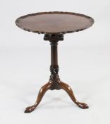 A George III mahogany tripod table, the circular top with piecrust border and birdcage movement, on