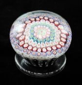 A Clichy millefleur piedouche paperweight, c.1850, with concentric rings of canes within a purple
