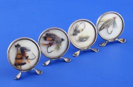 A cased set of four Edwardian/George V novelty silver ""fishing fly"" menu holders, of disc form,