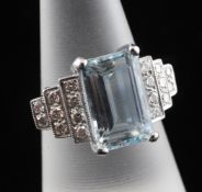 An Art Deco style 18ct white gold, aquamarine and diamond dress ring, the central aquamarine