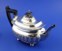 A late Victorian demi fluted silver teapot by Walker & Hall, of rounded rectangular form, on bun