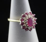 An 18ct gold, ruby and diamond cluster ring, of oval form, size L.