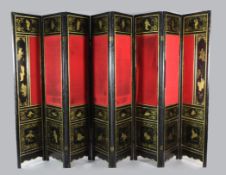 An early 20th century black lacquer and parcel gilt chinoiserie eight fold screen, decorated with