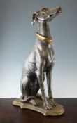 A 20th century carved painted and parcel gilt model of a seated greyhound, on stepped cartouche