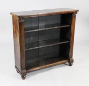 An early 19th century rosewood open bookcase, the sides with moulded fluted columns, on turned