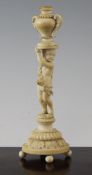 A 19th century Dieppe carved ivory figure of a cherub supporting an urn, on a gadrooned and stiff