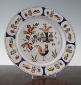 A Bristol delft dish, c.1740, painted with a cockerel amid a basket of flowers and a vase, within