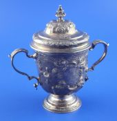 A George II small silver two handled pedestal cup and cover, with engraved armorials and later