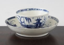 A rare Worcester `Candle Fence Pavilion` pattern tea bowl and saucer, c.1775, printed in underglaze