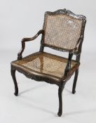 An 18th century French stained and carved beech fauteuil, with cane back and seat, the apron