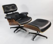 A buttoned black leather swivel lounge chair and matching footstool, after a design by Charles