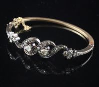 An early 20th century gold and rose cut diamond set hinged bracelet, of overlapping design.