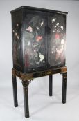 An early 20th century chinoiserie lacquer cabinet on stand, fitted two doors, decorated with birds